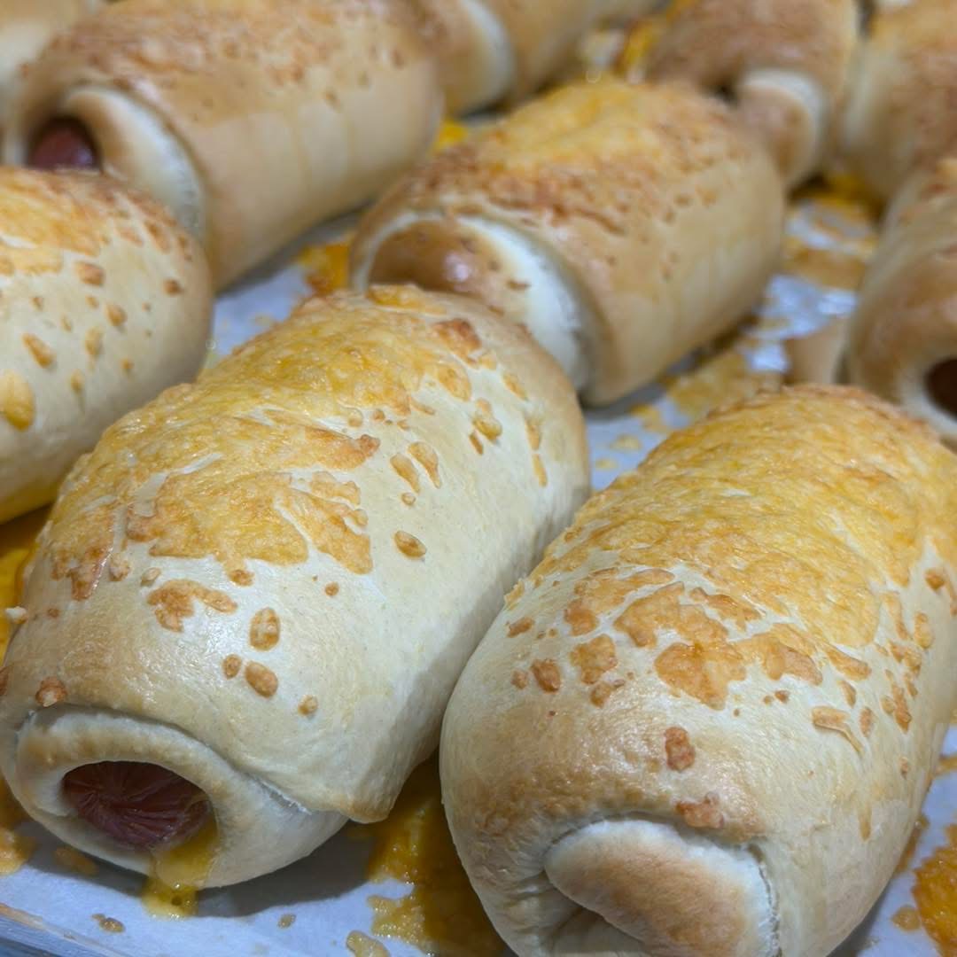 Cheddar-topped kolaches lined up on parchment